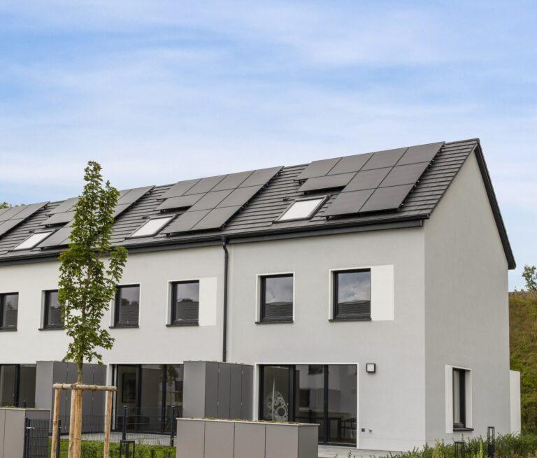 Reihenhaus im modernen MoVida Neubauprojekt mit Dachsolaranlage und Blick auf die begrünte Außenfläche zur Miete