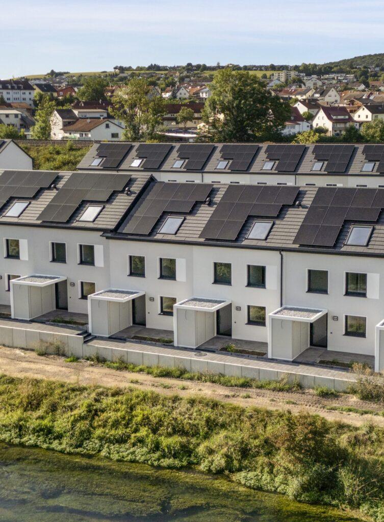 Moderne MoVida Reihenhausanlage in Flusslage mit großflächiger Photovoltaikanlage auf den Dächern für nachhaltige Energieversorgung zur Miete