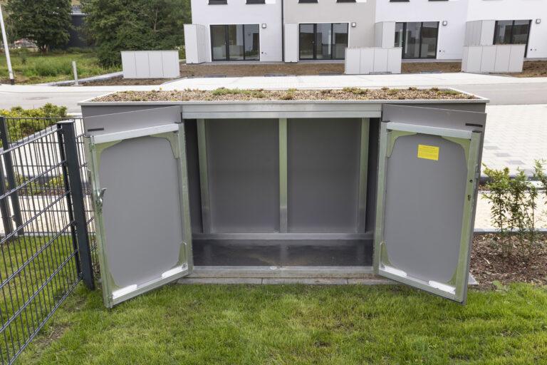 Movida Neubau Müllbox im Außenbereich mit geöffneten Türen und begrüntem Dach