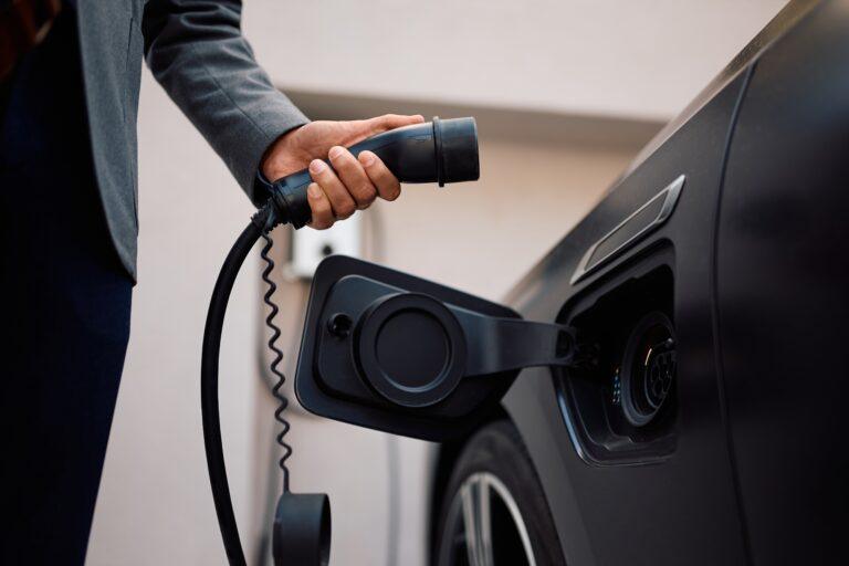 Nahaufnahme eines Elektroautos beim Laden an einer Ladestation in einer Movida-Immobilie zur Miete.