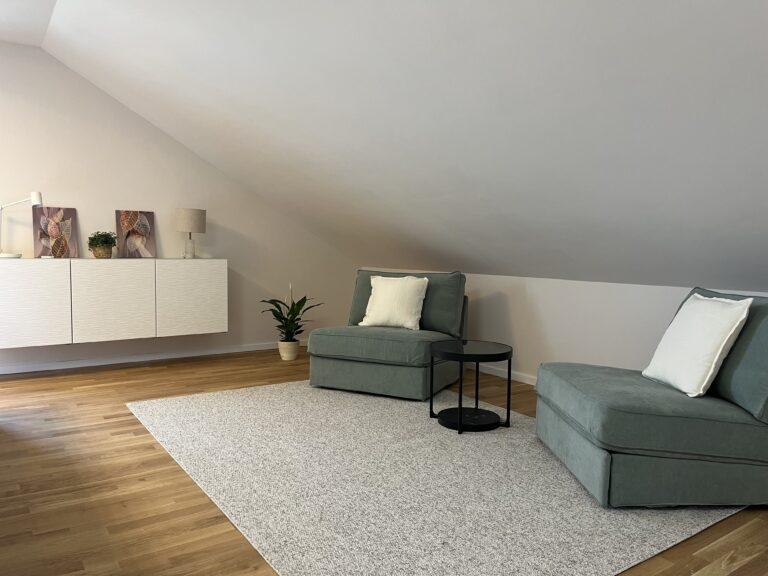 Helles modernes Studio im Dachgeschoss mit Fenster und Sesseln im MoVida Haus