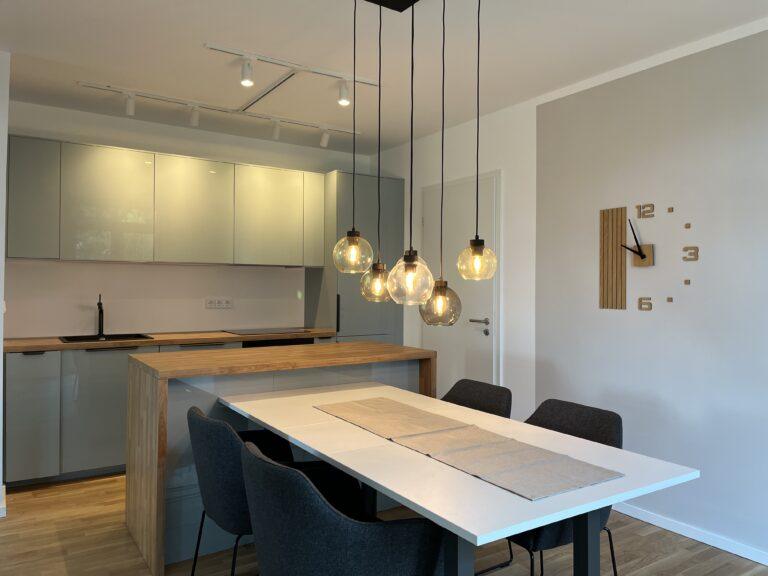 Moderner Ess- und Wohnbereich mit Einbauküche im MoVida Haus mit Induktionskochfeld und Backofen