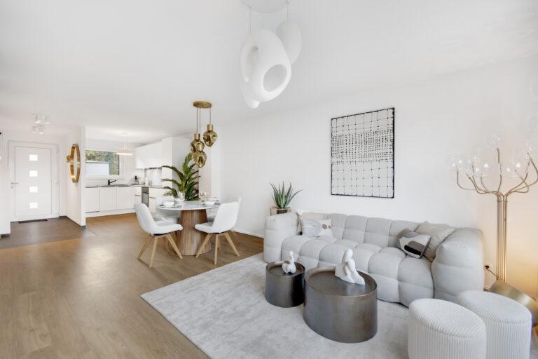 Modernes Movida Wohnzimmer mit Essbereich, offener Küche, heller Einrichtung und goldenen Designelementen