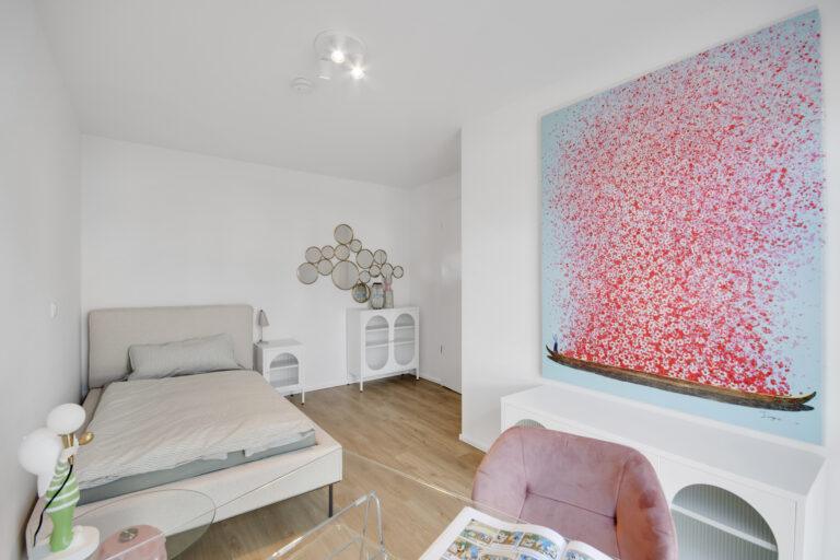 Modernes Gästezimmer im Reihenhaus mit Bett, Holzfußboden, Designmöbeln und heller Einrichtung.