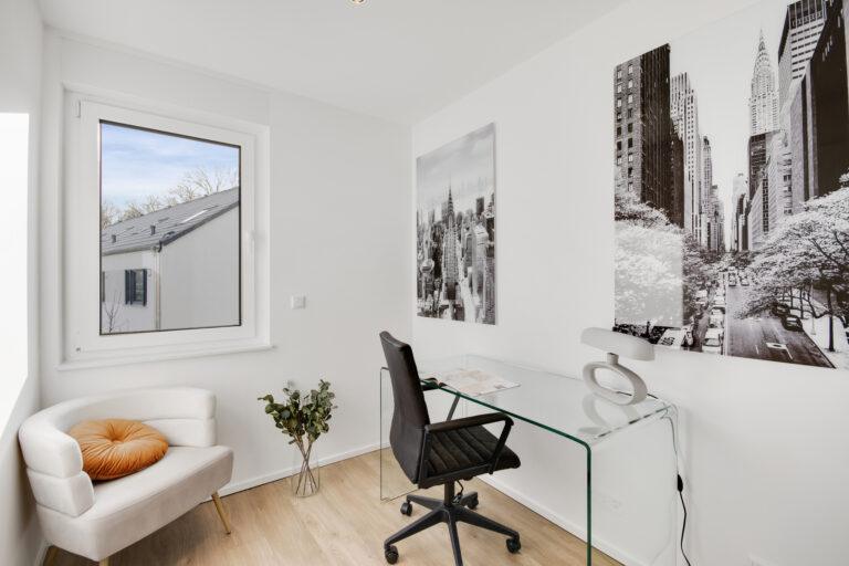 Modernes Homeoffice im Reihenhaus mit Glas-Schreibtisch, Designstuhl, Tageslicht und hellem Holzfußboden.