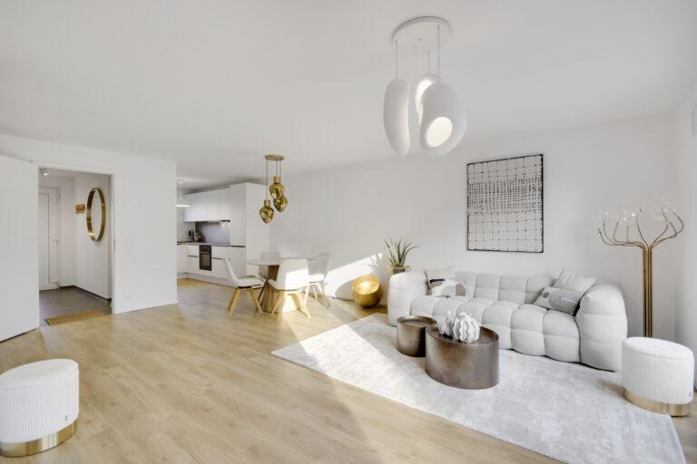 Helles modernes Wohn- und Esszimmer mit offener Küche, Designermöbeln, Holzfußboden und großer Fensterfront in einem Reihenhaus.