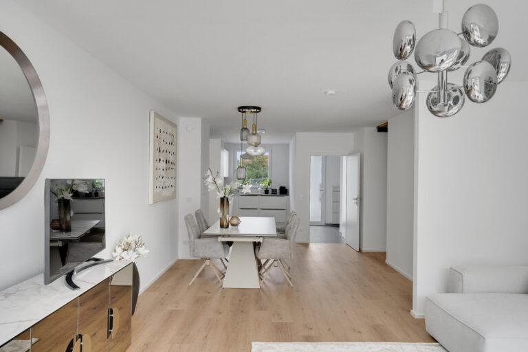 Modernes Esszimmer mit Blick ins Wohnzimmer und offene Küche in einer Movida-Immobilie mit 165 Quadratmetern Wohnfläche zur Miete.