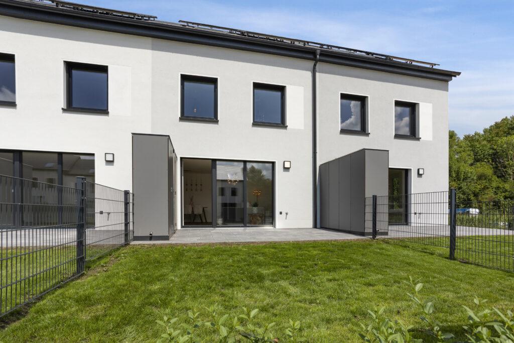 : Movida Haus Neubau mit Terrasse, Garten und großen Fenstern bei Sonnenschein zur Miete