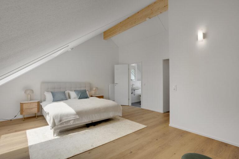 Modernes Movida Schlafzimmer im Dachgeschoss mit Doppelbett, Holzboden und Zugang zum Ensuite-Bad
