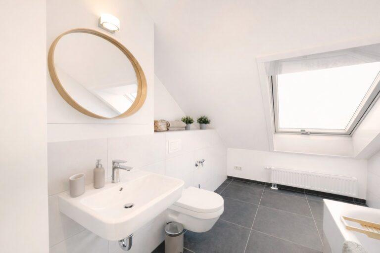 Modernes Badezimmer im Dachgeschoss eines Movida Living Reihenhauses mit Dachfenster und heller Ausstattung