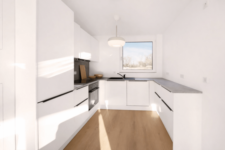 Moderne Einbauküche in einem Reihenhaus zur Miete mit hellem Design, großem Fenster und hochwertiger Ausstattung